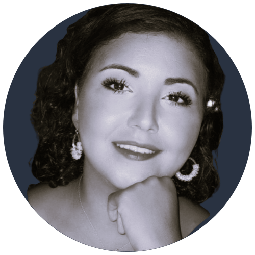 Portrait d’Adila en noir et blanc, souriante, posant le menton sur sa main illustrant son témoignage en tant que consultante agile et scrum Master pour Extend.